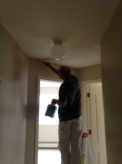 professional painter doing detailed work over a doorway
